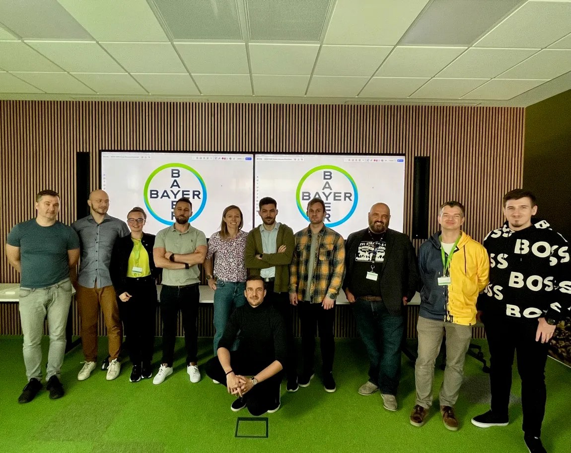 Olek with a workshop cohort in front of Bayer Digital Hub branding